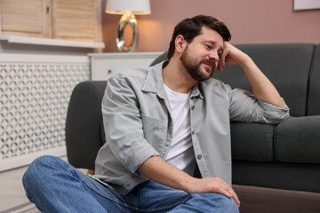 Fototapeta premium Unhappy man feeling extreme fatigue at home