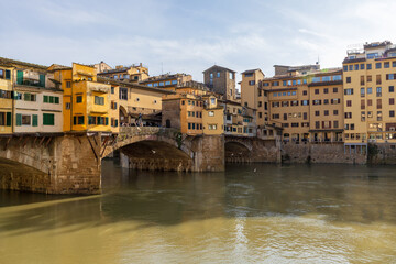 Obraz premium Peaceful Florence River View. Calm Waters Reflect Historic Architecture Scene. Gentle Reflections On Arno With Peaceful Historic Surroundings