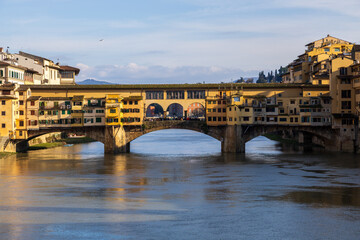 Obraz premium Florence Bridge Cast In Warm Sunset Glow Over Tranquil Water. Evening Scene Of Florence Featuring Silhouette Bridge And Reflective River Ambiance