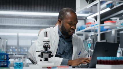 Molecular biologist in lab analyzing batch of blood samples for red blood cell abnormalities....