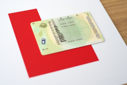  British provisional licence with L plate on wooden background.