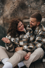 Naklejka premium Couple enjoys time together by the lake on Valentines Day with smiles and warm jackets