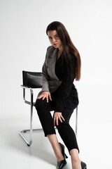 Fototapeta premium Confident business woman seated on chair in stylish jacket symbolizing calm authority and modern corporate fashion