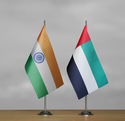 Two table flags of India and Emirates on a blurred gray background