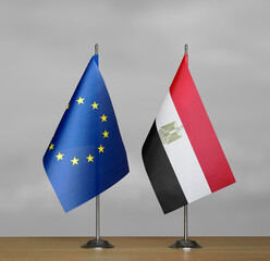Two table flags of the European Union and Egypt on a blurred gray background