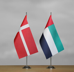 Two table flags of Denmark and Emirates on a blurred gray background