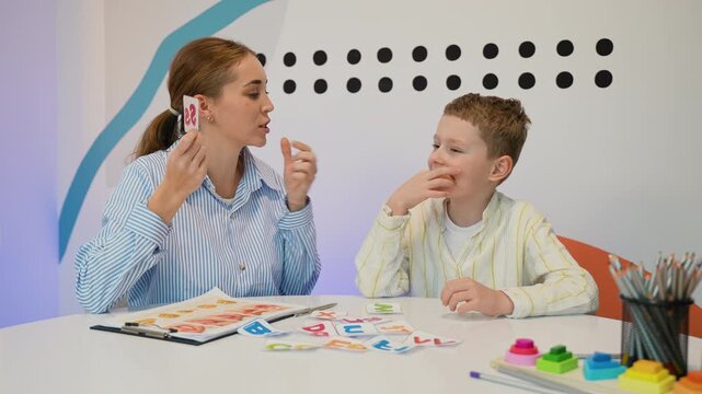 Speech therapist working with boy on articulation and pronunciation