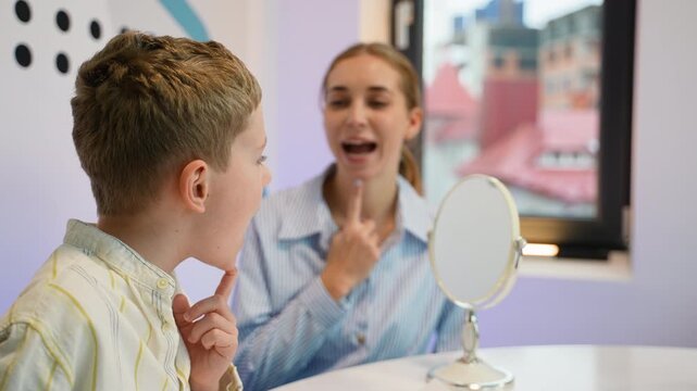 Speech therapist working on articulation with a young boy