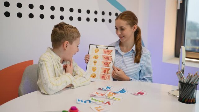 Speech therapist working with young boy on articulation
