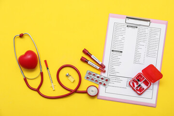 Blood samples of cortisol with stethoscope, pills and laboratory test form on yellow background. Medical concept © Pixel-Shot
