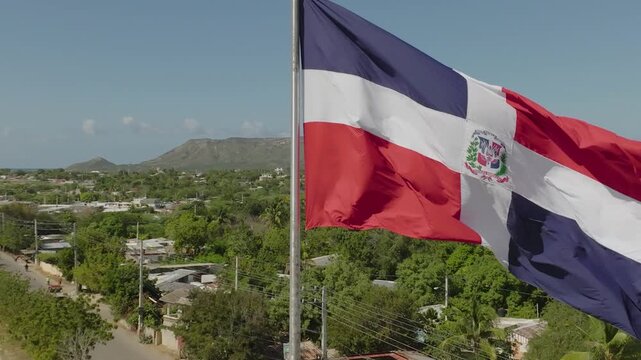 Bandera de Rep&uacute;blica Dominicana sobre asta, detras el Morro de Montecristi