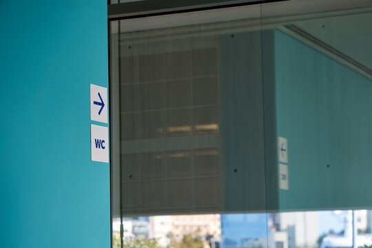 Panneau indiquant la direction des toilettes sur le mur du centre commercial.