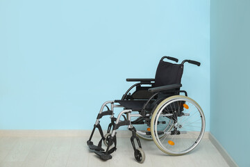 Empty wheelchair near blue wall