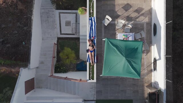 Top down static aerial shot of woman sunbathing