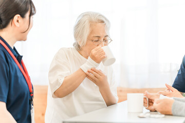 Obraz premium Senior woman and female occupational therapist doing swallowing training at a nursing home or care facility