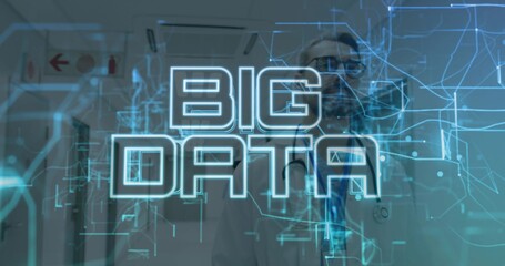 Examining doctor in lab coat, stethoscope and tie interacting with BIG DATA hologram in corridor