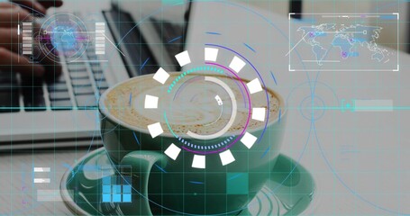 Sitting green cup with latte art on table, hands in dark-sleeve typing on laptop, HUD overlaying