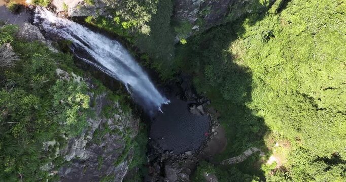Aerial drone video of Jade Curtain Waterfall (Yu Lian Spring) on Mount Lu, Jiangxi &mdash; slow left-rotating descent for dramatic overhead view over cliffs, forest, and cascading water.  
