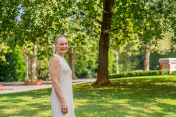 Mature woman smiling in park after chemotherapy