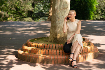 Woman talking on smartphone resting in park