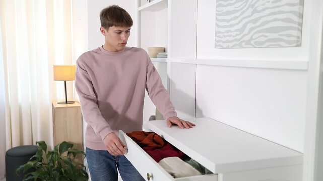 Amnesia. Thoughtful man forgetting why he opened drawer then remembering at home