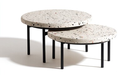 Two round coffee tables, stacked, with a light beige terrazzo top and black metal legs
