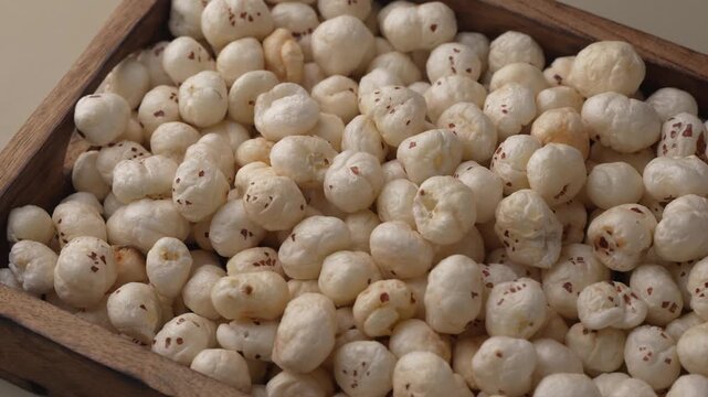 Makhana on wooden tray closeup shot in panning motion.
