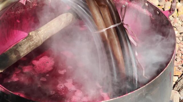 Dyeing fabric with lac to obtain natural colors using the ancient method of boiling in a hot pot.