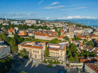 Obraz premium Aerial view of Lausanne featuring the historic old town, Lausanne Cathedral and surrounding cityscape with Lake Geneva and the Alps in the background, Switzerland