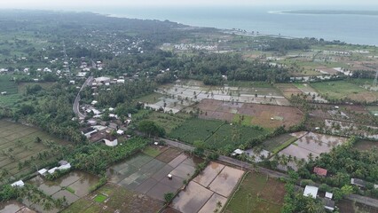 Obraz premium Aerial View of Tropical Rural Landscape with Rice Fields and Coastal Villages