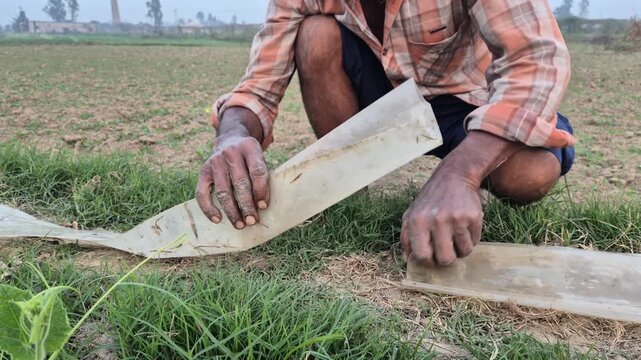 Professional cinematic video of a farmer connecting irrigation pipes in a field, Agricultural Water Management in Bangladesh, 4K UHD 30fps.