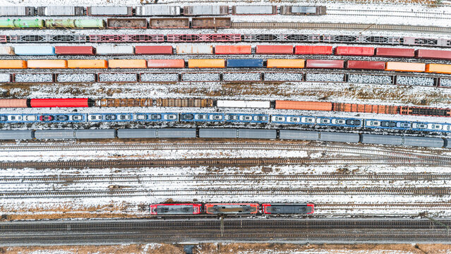 Winter aerial view of a German railway yard in Bavaria showing freight cars on parallel tracks and colorful wagons used for cargo transportation