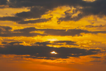 Fototapeta premium Clouds in the sunset sky A breathtaking sunset with vivid orange and yellow hues paints the sky