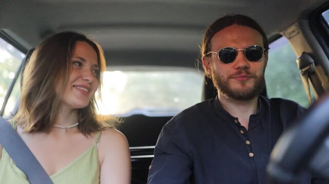 a young couple is traveling by car