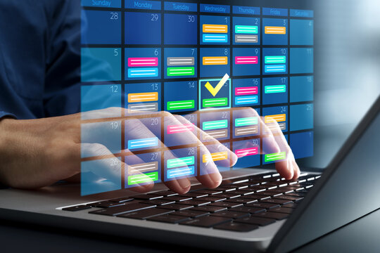 Scheduling and calendar management. Business appointments and task planning. Businessman using a calendar application on a laptop computer.