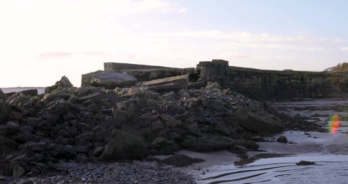 Landscape shot of the rocky remains of the Galway Bay Promenade, featuring geological textures and a calm Atlantic shoreline