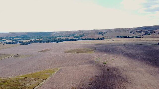 An aerial drone shot passing over the vast open cultivated farmland of the South African Highveld
