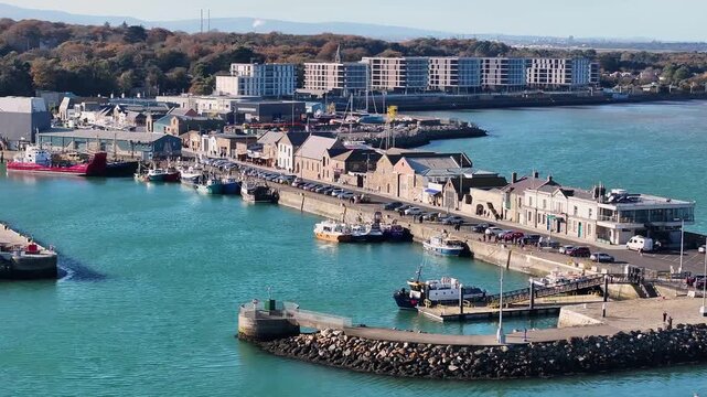 West Pier in Howth Harbour with promenade, restaurants and fish shops. Ireland town aerial