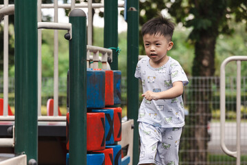 Happy asian boy smiling and playing in playground