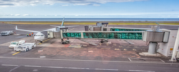 Fototapeta premium Avion de ligne relié à sa passerelle d’embarquement 
