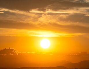 A vibrant sunset paints the sky with warm hues, the sun shining brightly above a distant mountain range. Fluffy clouds drift