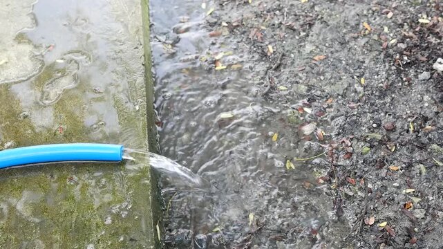 Water Flowing from Hose onto Ground Outdoor 