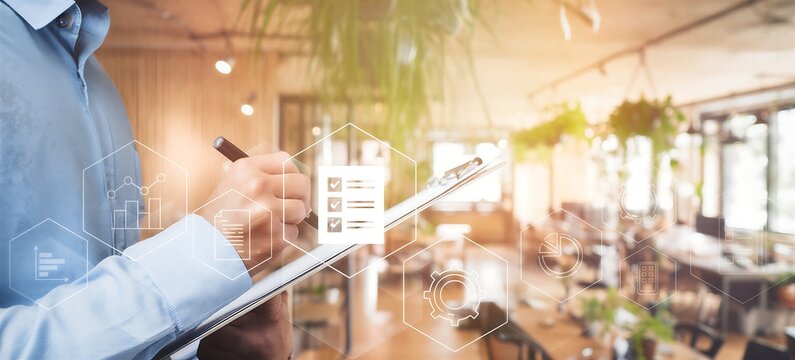 Business professional analyzing digital real estate market trends with futuristic interface and checklist on transparent screen