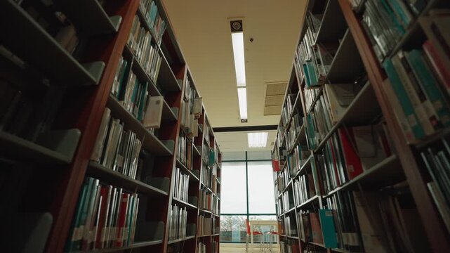Interior of a university library with bookshelves arranged in rows at a university in Bangkok, Thailand.