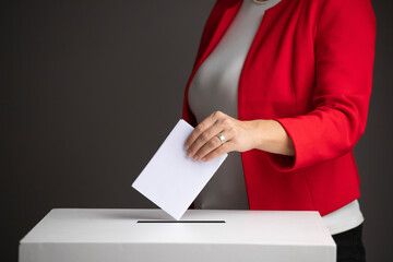 The voter holds his vote ballot paper and places it in the ballot box. Election concept.