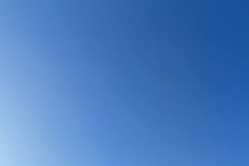 Clear blue sky offering an expansive, vibrant background with a subtle color gradient from lighter to deeper blue, representing concepts of peace, freedom, and space