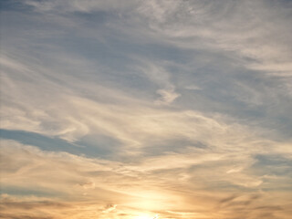 Obraz premium Warm sunlight creating a soft gradient across the sky, with delicate cirrus clouds painting the atmosphere during sunset or sunrise over port washington, new york