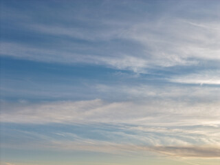 Obraz premium Sky showing a clear blue expanse with delicate, elongated white cirrus clouds stretching horizontally across the frame, creating a serene and expansive natural background