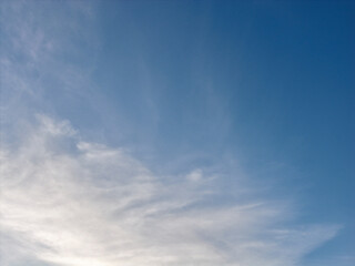 Fototapeta premium Blue sky and light feathery white clouds creating a peaceful and expansive backdrop, ideal for natural themes, weather concepts, or copy space designs