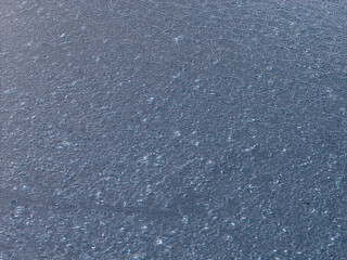 Fototapeta premium Water surface shows intricate patterns of refreezing ice crystals, creating a delicate frozen texture on the bay at plum beach point drive in port washington, new york